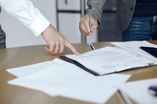 business-men-sitting-lawyers-s-desk-people-signing-important-documents_1157-40455