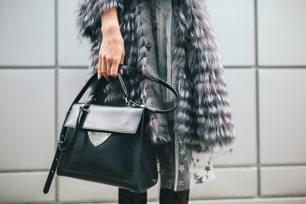 close-up-accessories-details-stylish-woman-walking-city-warm-fur-coat-winter-season-cold-weather-holding-leather-bag-street-fashion-trend_285396-4704